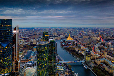 High angle view of city buildings against cloudy sky