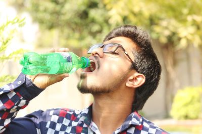 Portrait of young man drinking glasses outdoors