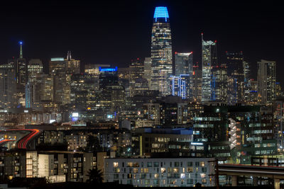 Illuminated buildings in city against sky at night