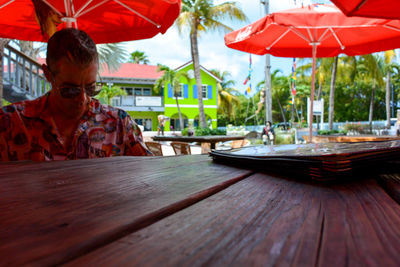 Man with red umbrella on table in restaurant