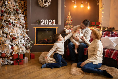 Full length of father with daughter sitting on floor