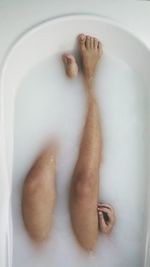 High angle view of legs in water