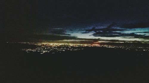Aerial view of illuminated city against sky at night