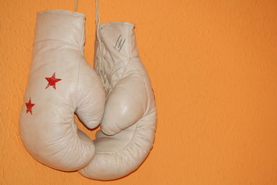 Close-up of boxing gloves hanging against wall