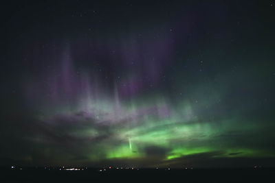Low angle view of illuminated buildings against sky at night