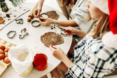 Two sisters are preparing gingerbread cookies for christmas. preparation for christmas and new year