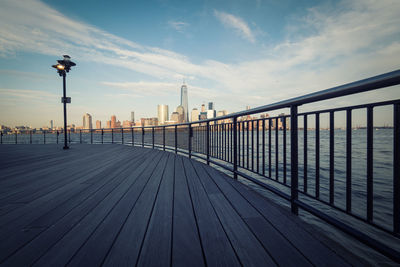 Promenade by hudson river against one world trade center in city