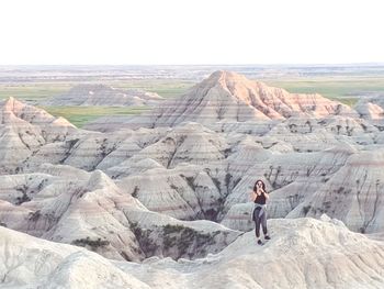 Man standing on rock against sky