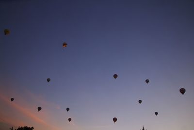 Low angle view of hot air balloons against sky during sunset
