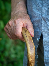 Midsection of man holding banana