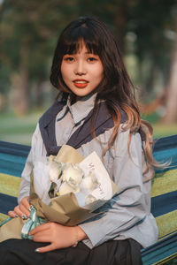 Portrait of smiling young woman using mobile phone