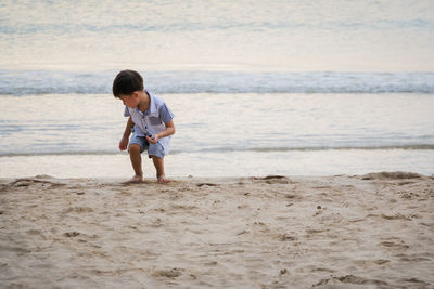 Boy playing on sand at beach