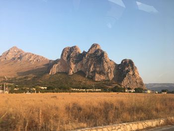 Scenic view of land and mountains against clear sky