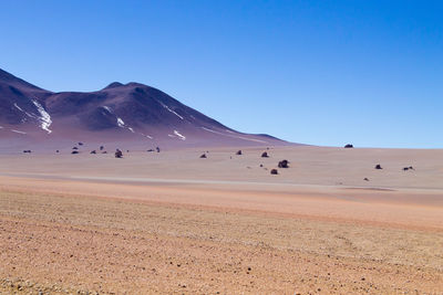 Scenic view of desert against clear blue sky