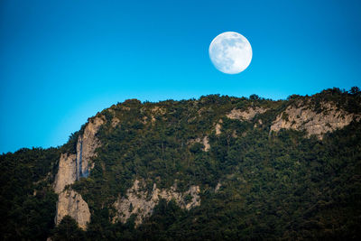 Scenic view of full moon against blue sky