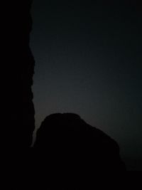 Low angle view of silhouette rock against sky at night