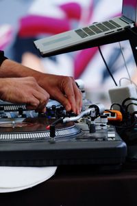 Cropped hands playing turntable on stage