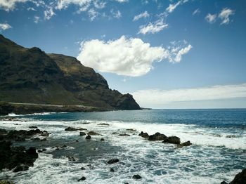 Scenic view of sea and mountains against sky