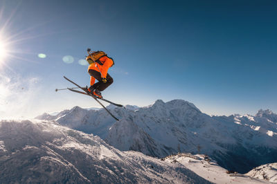 Winter vacation at the ski resort. skier quickly fly in the air doing a stunt heli-skiing on the