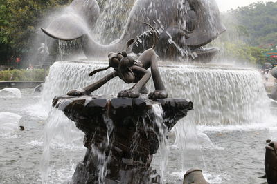 Full length of man standing on rock at fountain