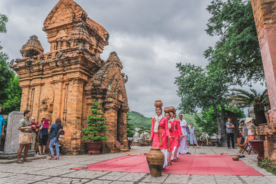 People at temple against sky