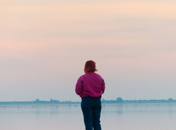 Rear view of woman looking at sea against sky