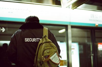 Rear view of man standing in bus