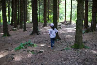 Full length of young girl running in forest