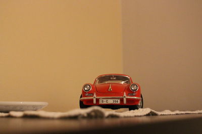 Close-up of toy car on table against wall