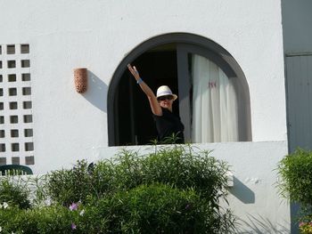 Man standing by window of building