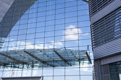 Low angle view of glass building against sky