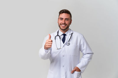 Portrait of smiling man standing against white background