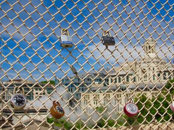 Graffiti on chainlink fence against sky