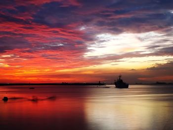 Scenic view of sea against dramatic sky during sunset