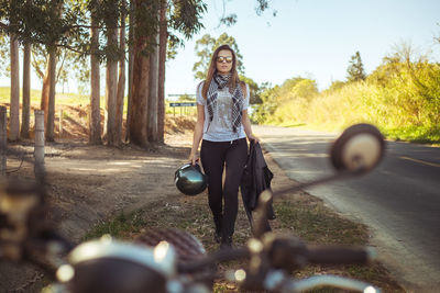 Portrait of young woman standing against clear sky