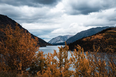 Scenic view of lake by mountains against sky