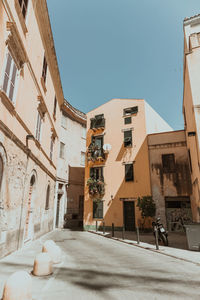 Street amidst buildings against clear sky