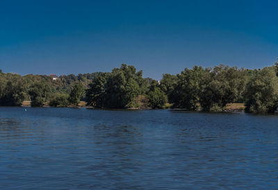 Scenic view of lake against clear blue sky