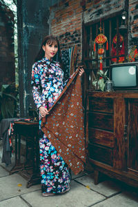 Woman holding textile while standing at home