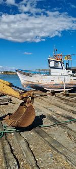 Fishing boats moored on beach against sky