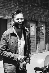 Portrait of smiling man standing against built structure