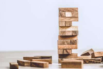 Stack of wooden table against clear sky