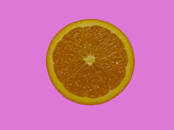 Close-up of lemon slice against pink background