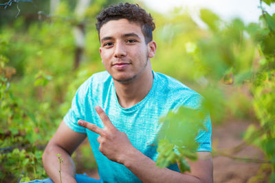 Portrait of young man showing peace sign