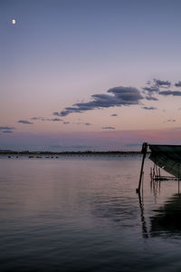 Pier over sea against sky at sunset