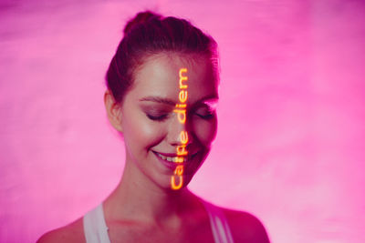 Portrait of woman against pink background