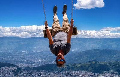 Rear view of man on mountain against sky