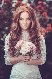 Portrait of a beautiful young woman with red flower