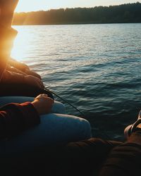 Low section of man relaxing on boat in lake