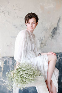 Portrait of beautiful young woman with white flower